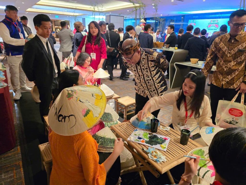 Tour group joining a conical hat painting workshop in HCMC