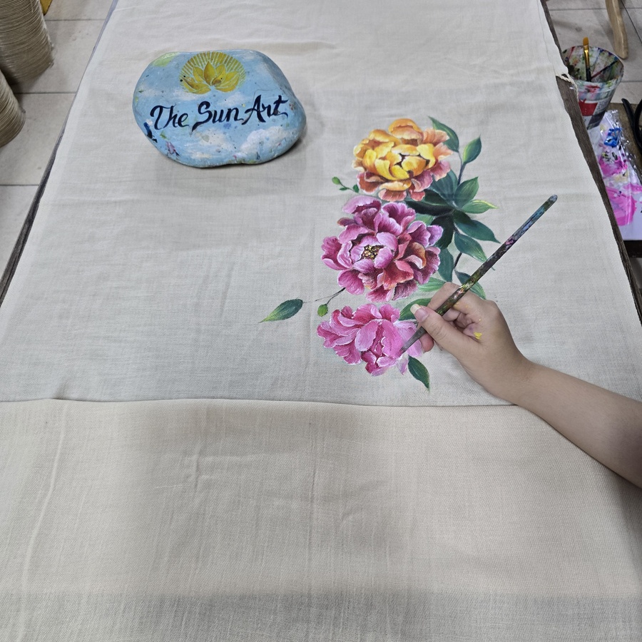 Hand-painted peony flowers on a linen scarf at The Sun Art studio in Ho Chi Minh City
