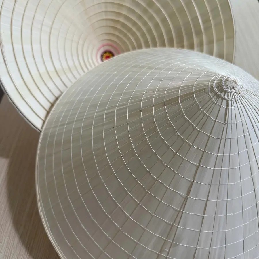 Close-up of the bamboo frame and white stitching of a handmade Vietnamese conical hat